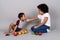 Young cute African siblings together against gray background