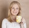 Young cute blond girl drinking coffee close up on