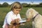 Young cute boy giving water to his dog