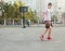 A young cute boy plays basketball at the outdoor streetball court on a sunny summer day. Teenager player in action dribbling