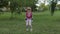 Young cute child girl in sportswear making fitness jump exercises outdoors in park. Workout for kids