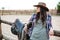 Young cute cowgirl leaning on the ranch fence