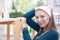 Young cute girl with clay mask pattern on her face in pink headband with ears on background shelves with skin products