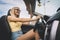 Young cute girl preens while driving. blonde admires herself in mirror. Happy female driver behind the wheel. woman lowers the sun