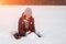 Young cute girl sits in the snow and makes a ball for a snowman. Artistically colored photography