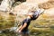 Young cute girl waving hair in the water, waterfall thai travel