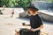 Young cute modern millennial hipster girl in hat dressed in black relax and work in Skatepark.