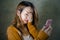 Young cute and sad Asian Korean girl feeling broken heart and desperate holding mobile phone suffering relationship break up