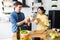 Young cute smiling couple cooking together at kitchen at home. A young, sympathetic couple eating freshly baked baguette in their