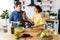 Young cute smiling couple cooking together at kitchen at home. A young, sympathetic couple eating freshly baked baguette in their