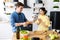 Young cute smiling couple cooking together at kitchen at home. A young, sympathetic couple eating freshly baked baguette in their