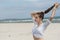 Young cute woman on the beach fixing her ponytail