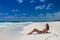 Young cute woman lying and getting sun at tropical sand beach