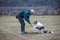 Young cynologist, a dog trainer trains a four-legged pet Australian Shepherd in basic commands using treats. Love between dog and