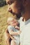 Young dad holds a newborn baby while walking in nature. happy father is wearing shorts and a t-shirt. International Father`s Day