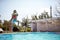 Young dad jumping in to a swimming pool with his daughter in his arms