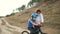 Young dad teaches his daughter to ride a Bicycle in medical masks and a Bicycle helmet in nature. Protection FROM covid-19