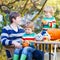 Young dad and two little kids making jack-o-lantern