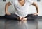 Young dancer pressing legs down into butterfly position to stretch hips in the studio