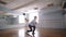 Young dancer is rehearsing dance for a performance. Large spacious dance studio. Window and large mirror on the