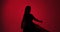 Young Dancer's Striking Silhouette on Red Background