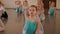 Young dancers perform gymnastic exercises during a warm-up in the classroom.