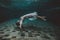 Young dark hair woman in vintage white dress swim underwater