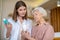 Young dark-haired cosmetologist demonstrating new cosmetic products to a female customer