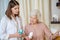 Young dark-haired cosmetologist demonstrating new cosmetic products to a female customer