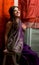 The young dark-haired woman in a beautiful Indian saris laughing happily sitting on the bright draped screen