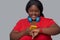 Young dark-skinned woman checking time on a watch and smartphone