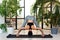 Young darkhair woman practicing yoga in the morning at her home near plants. The woman is engaged in self-determination