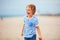 Young delighted boy, kid playing with a toy propeller, having fun on summer beach