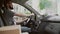 Young delivery man driving car with parcels on front seat