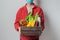 Young delivery man in protective face mask holding wooden box in hands. Man courier with shopping box. Safe online delivery from