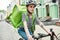 Young delivery woman in helmet with thermo bag or backpack riding a bike along the city, delivering food. Courier