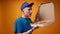 Young deliveryman in blue uniform opens a box of fresh pizza against yellow background