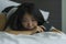 Young depressed Asian Korean woman on bed sad and worried checking online news about covid-19 virus outbreak on mobile phone