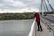 Young depressed homeless girl or woman standing alone on the bridge want to jump in the water of the river and to commit suicide