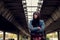 Young depressed homeless girl or woman standing alone under the bridge on the street on the cold weather feeling anxious abandoned