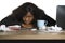 Young depressed and overwhelmed black African American business woman working in stress at office computer desk feeling upset and