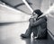 Young desperate adult woman sitting on the ground on subway unde