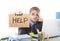 Young desperate businessman holding help sign looking worried suffering work stress at computer desk