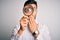 Young detective man looking through magnifying glass over isolated background cover mouth with hand shocked with shame for