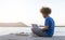 Young digital nomad man sitting on wooden pier at sea working on internet remotely at sunset - Traveling with a computer - Online