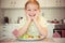 Young diligent happy boy at a table eating healthy meal