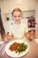 Young diligent happy boy at a table eating healthy meal with cu