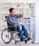 Young disabled injured man opening the fridge door