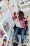 Young disabled woman reaching out for blanket at shelf