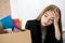Young dismissed female worker in office sitting near carton box